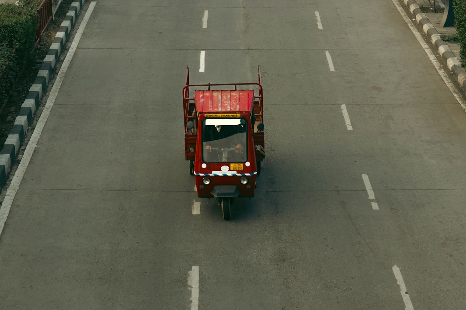 Light commercial tempo on a city road in Surat, Gujarat, India — no people or readable plates